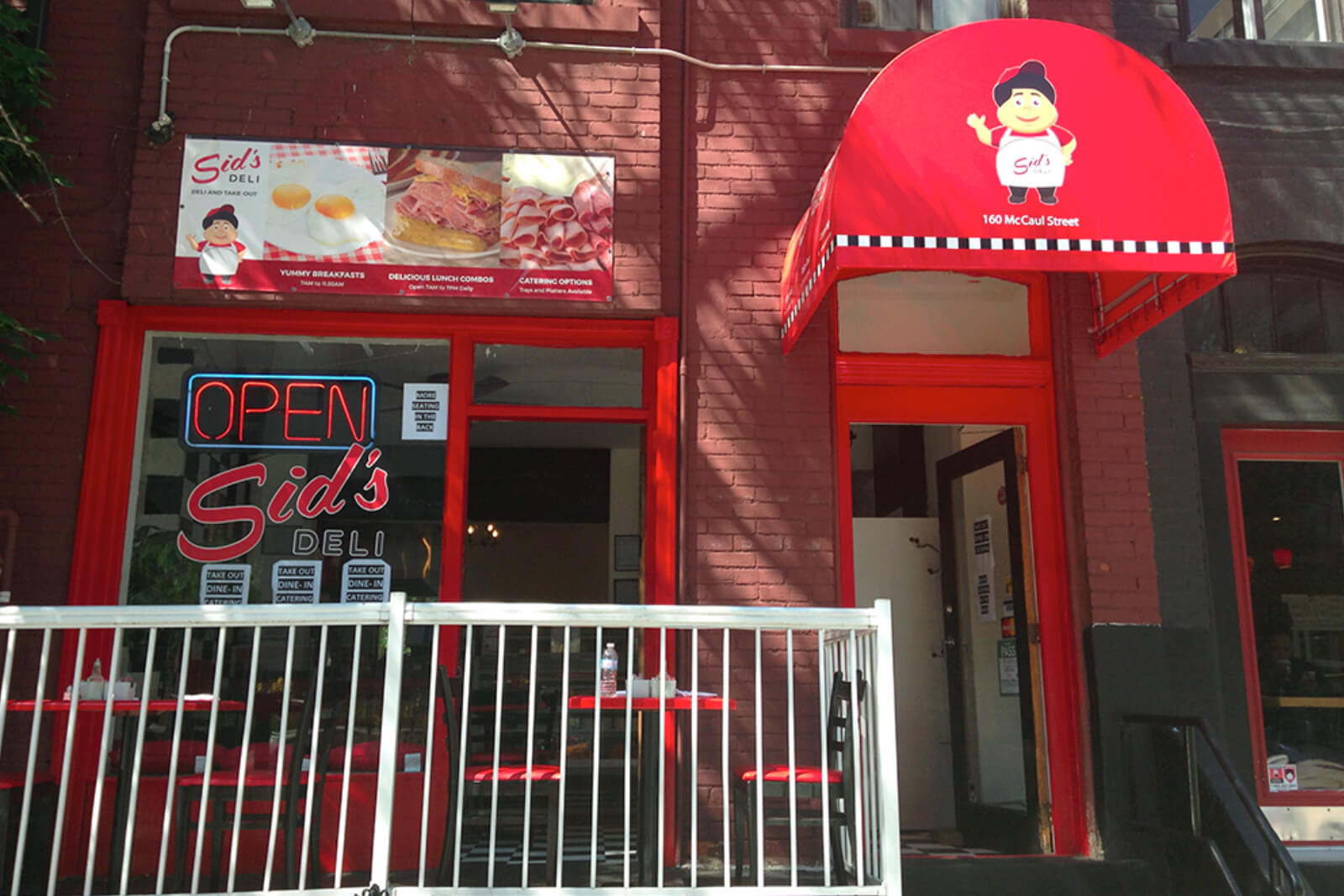 The exterior of the restaurant with a view of the awning and window decals